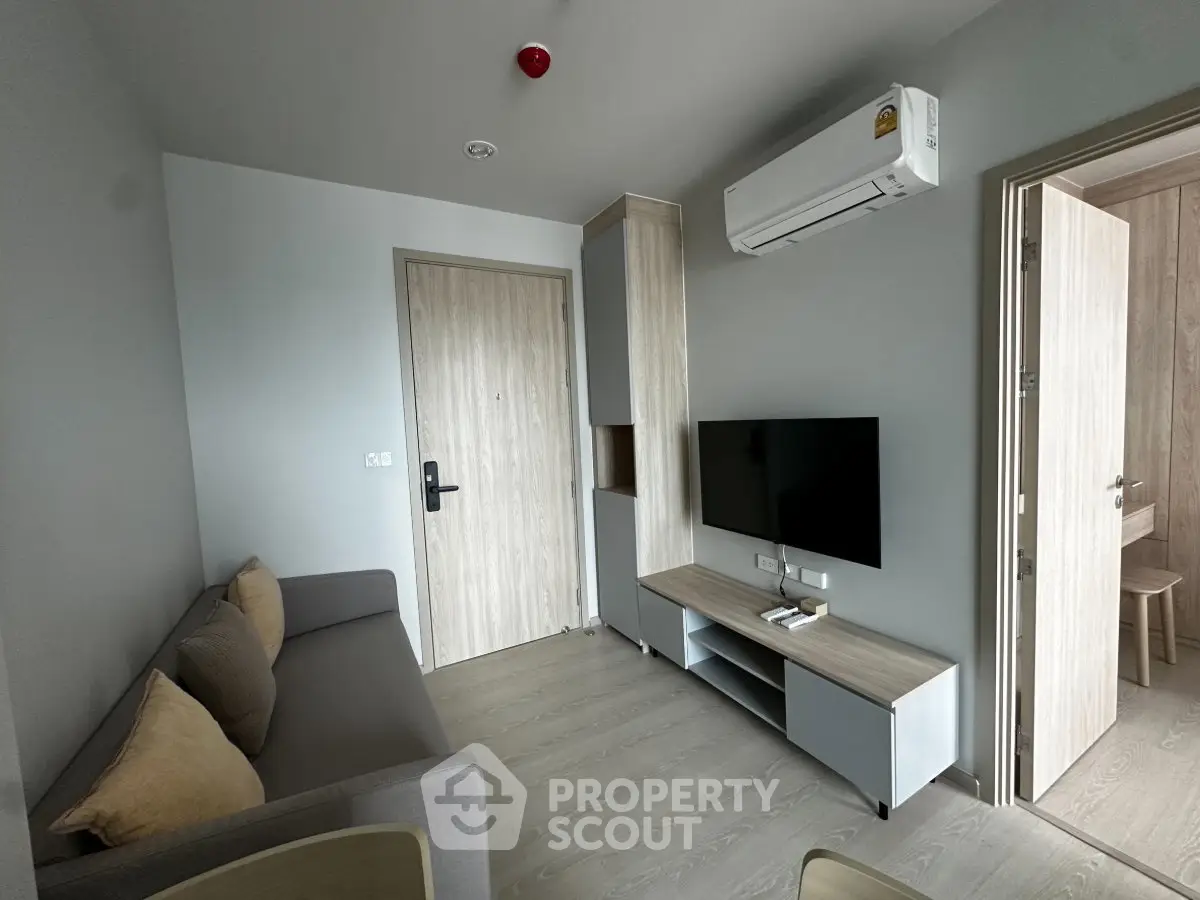 Modern living room with sleek furniture and wall-mounted TV in a stylish apartment.