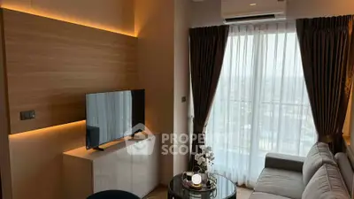 Modern living room with large window and stylish decor in a high-rise apartment.