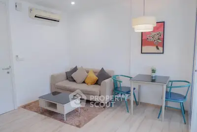 Chic modern living room with cozy sofa, stylish decor, and dining area in a bright apartment.