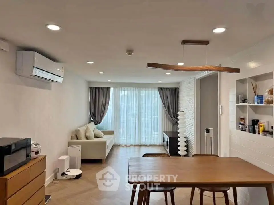 Modern living room with stylish furniture and natural light, featuring a cozy sofa and elegant dining area.