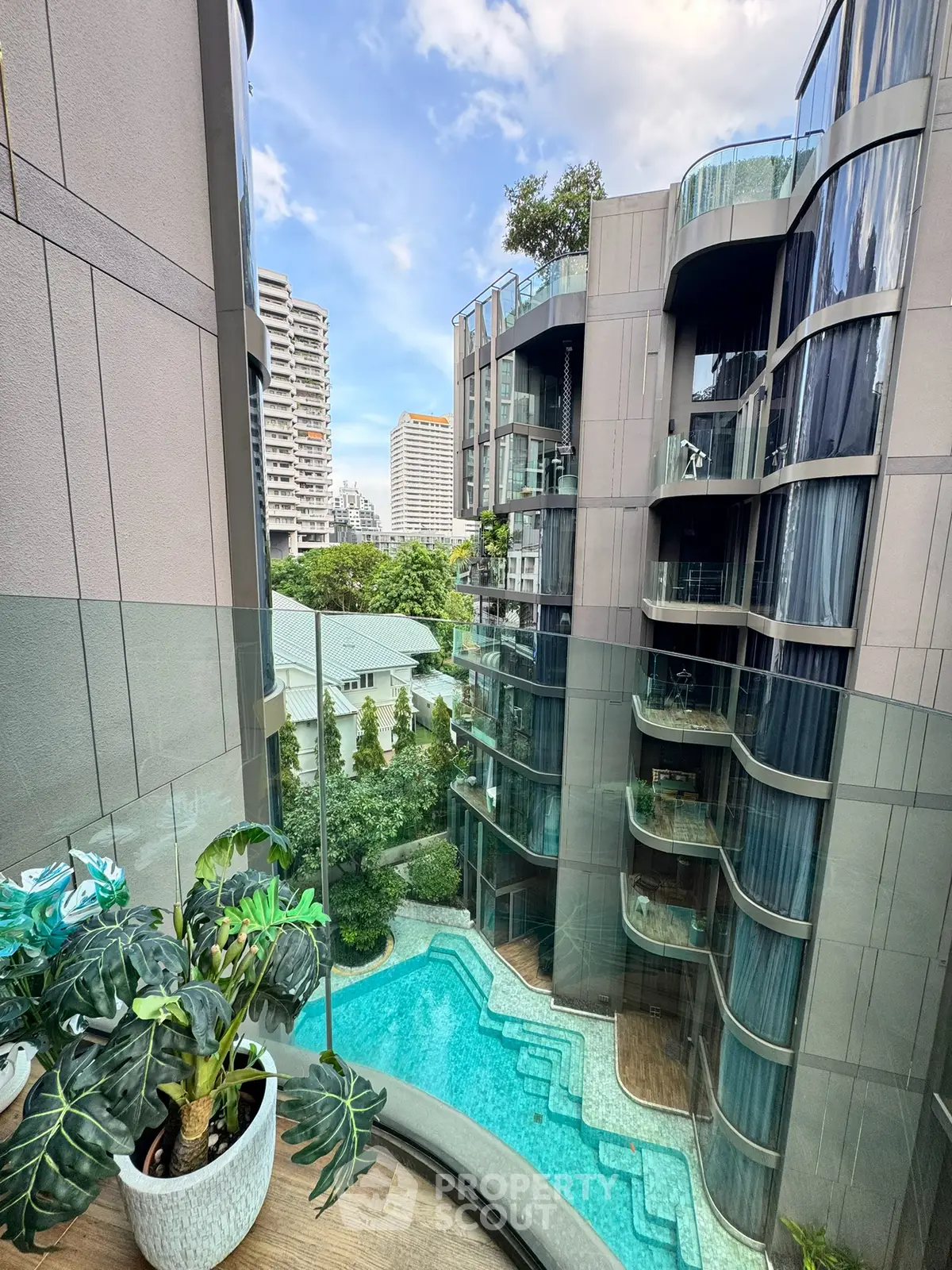 Luxurious modern apartment with pool view and glass balcony in urban setting.