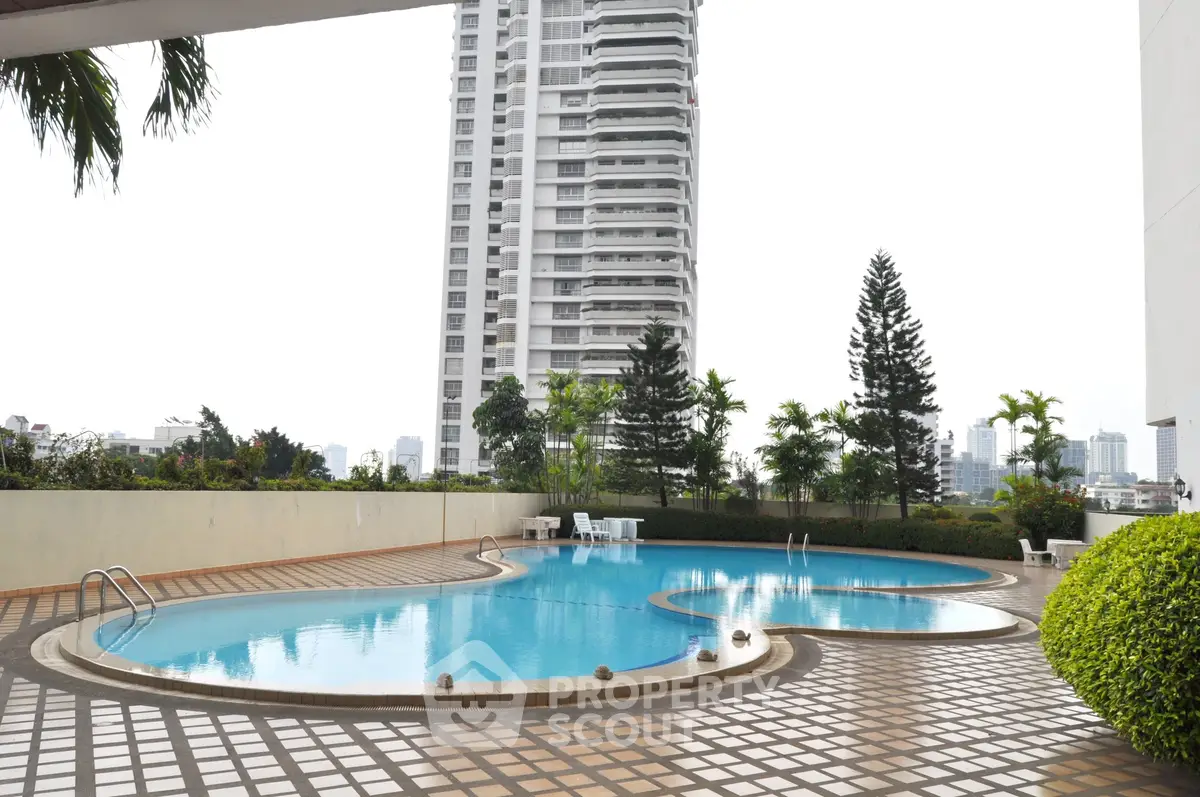 Luxurious high-rise building with serene pool and lush greenery