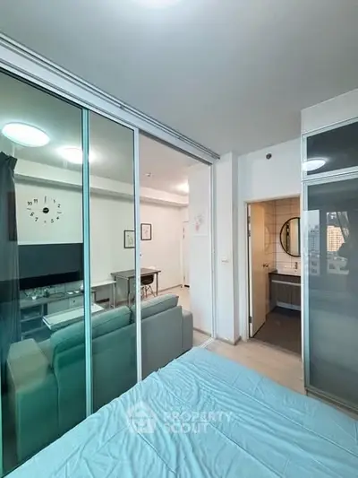 Modern apartment interior with glass partition, cozy living area, and stylish decor.