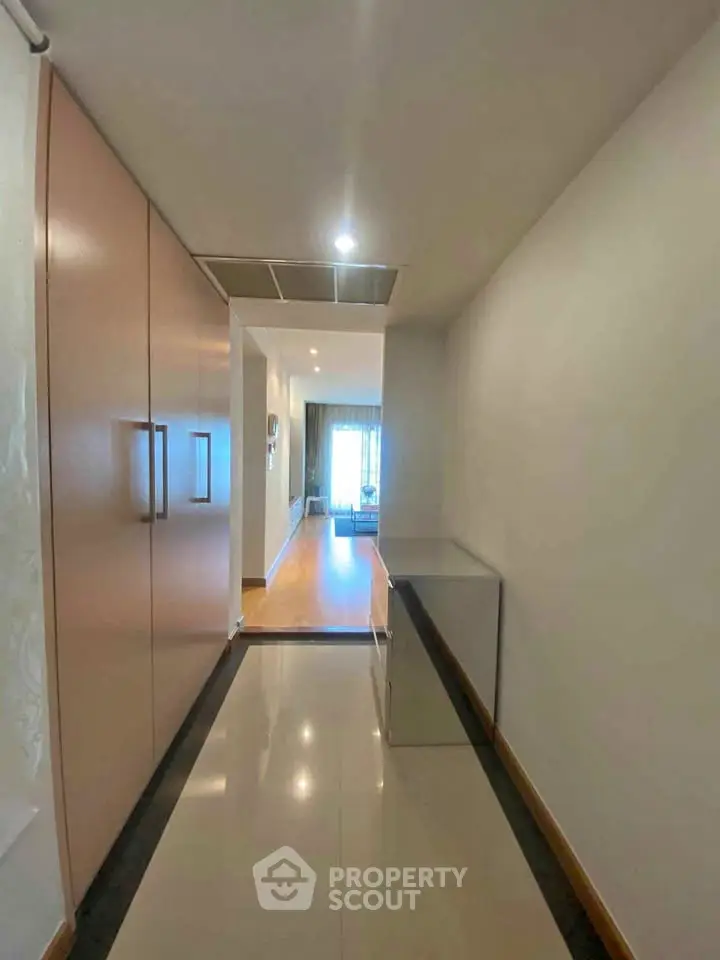 Spacious hallway leading to a bright living room with modern design and ample natural light.
