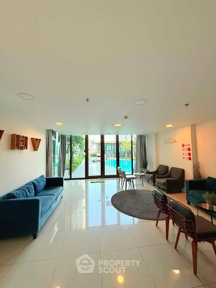 Spacious living room with pool view, modern furniture, and large windows for natural light.