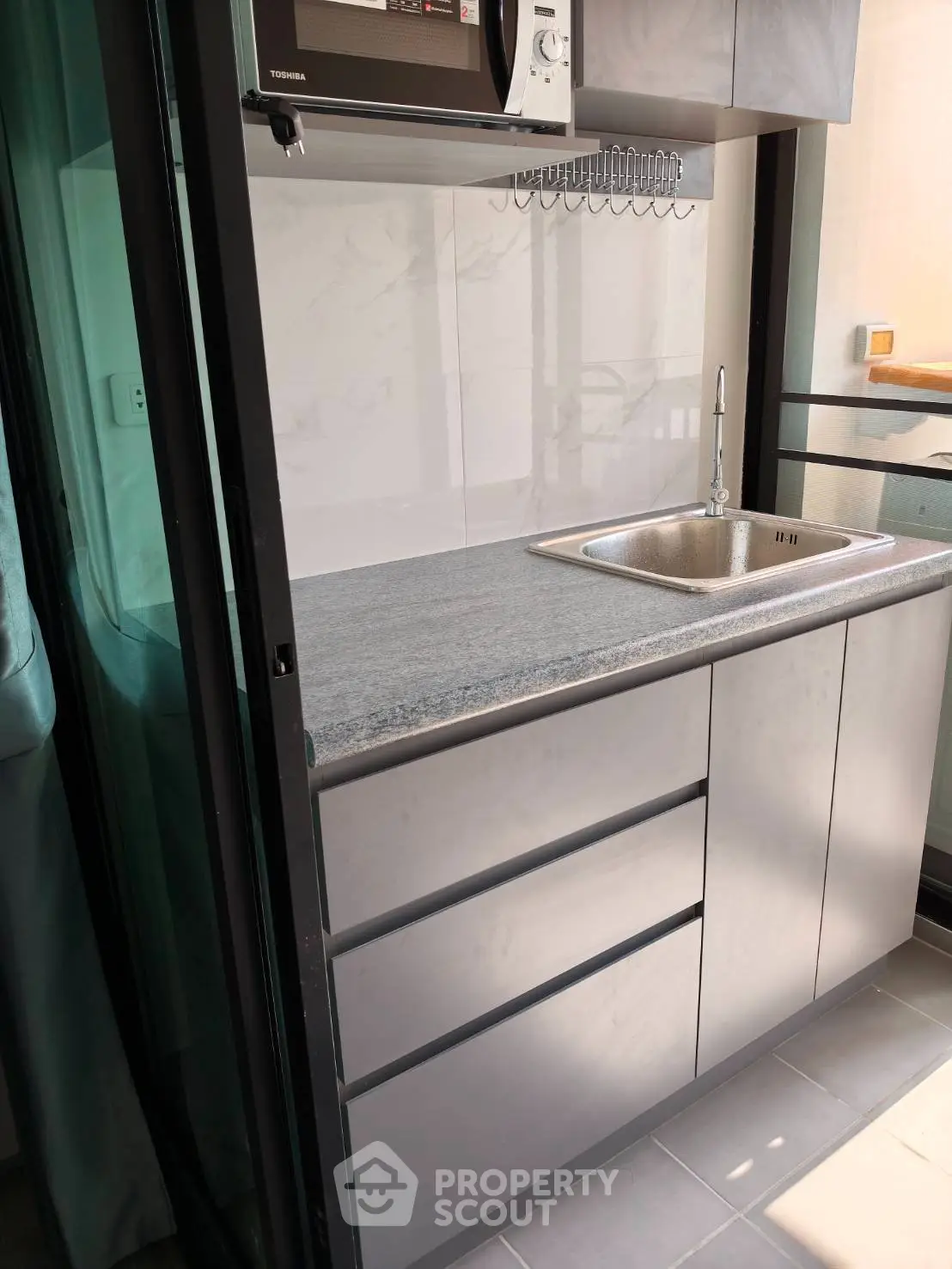 Modern compact kitchen with sleek cabinetry and stainless steel sink