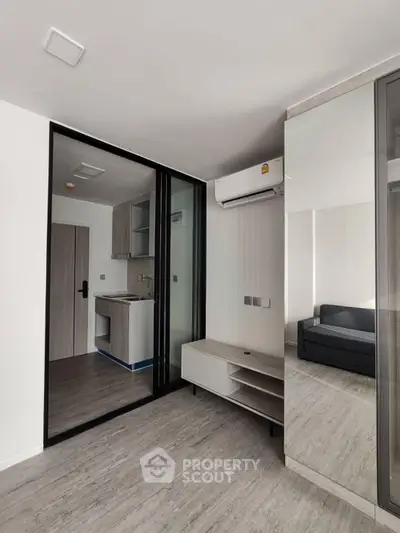 Modern apartment interior with sleek kitchen and living area, featuring minimalist design and ample natural light.