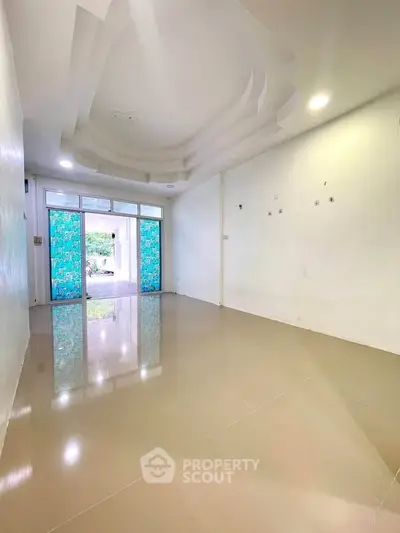 Spacious empty room with glossy tiled floor and modern ceiling design, perfect for customization.