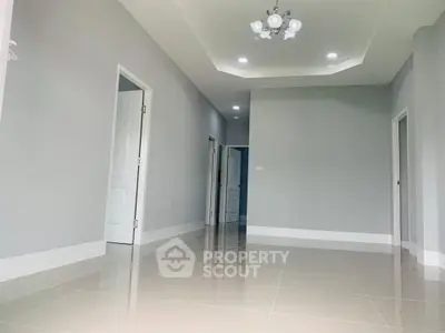 Spacious empty room with modern lighting and glossy tiled flooring