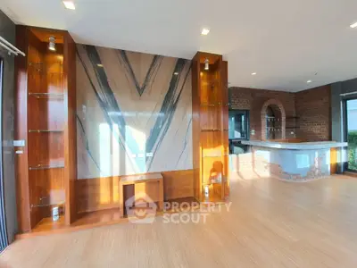 Spacious living room with elegant wooden shelves and modern bar area