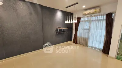 Modern living room with elegant lighting and large window, perfect for cozy gatherings.