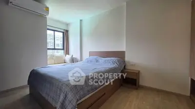 Cozy bedroom with natural light and modern furnishings in a stylish apartment.
