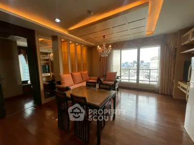 Luxurious living room with elegant chandelier and city view, featuring cozy seating and stylish decor.