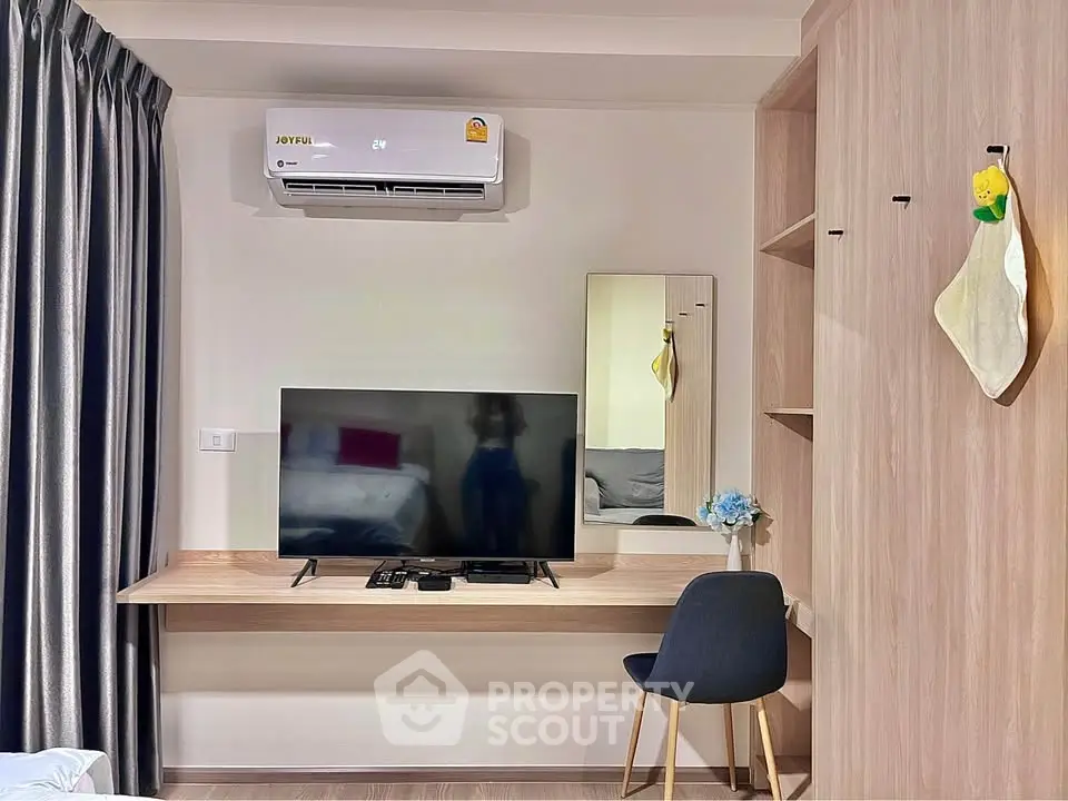 Modern living room with sleek TV setup and stylish furniture in a cozy apartment.