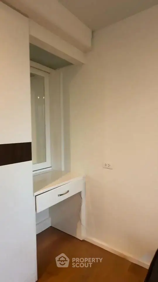 Compact study nook with built-in desk and window in modern apartment.
