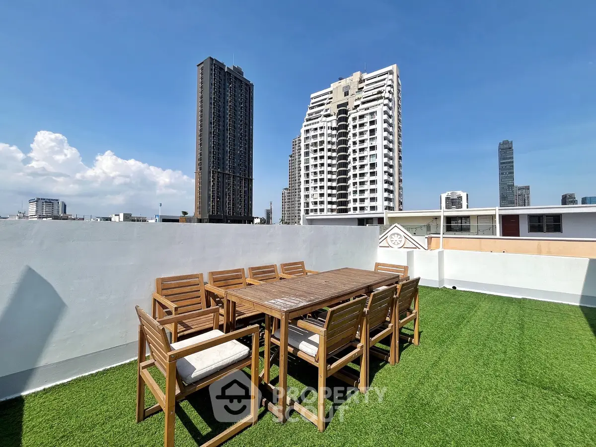 Stunning rooftop terrace with city skyline views and outdoor dining set.