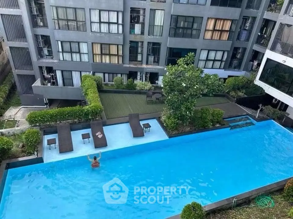 Modern apartment complex with a luxurious swimming pool and lush greenery, perfect for relaxation and leisure.