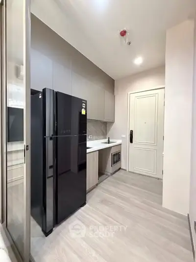 Modern kitchen with sleek black fridge and minimalist design