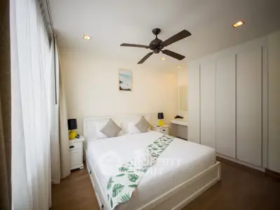 Spacious modern bedroom with elegant decor and ceiling fan