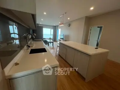 Modern open-layout kitchen with sleek countertops and ocean view, perfect for culinary enthusiasts.