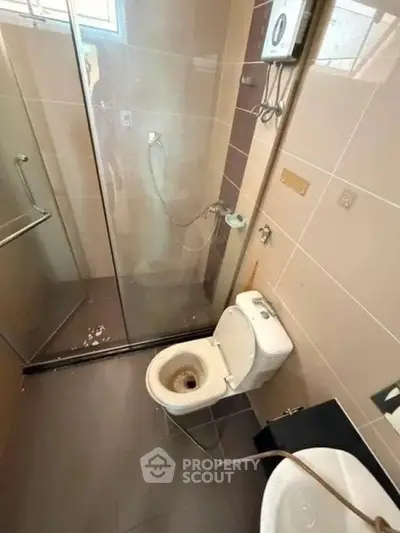 Compact bathroom with glass shower enclosure and modern fixtures.