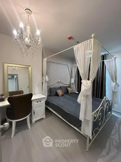 Elegant bedroom with canopy bed and chandelier, featuring a stylish vanity and modern decor.