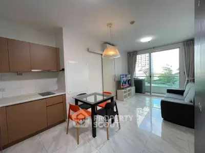 Modern open-layout living room with kitchen, featuring sleek furniture and large window with balcony view.