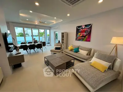 Spacious modern living room with stylish decor and large windows offering natural light.