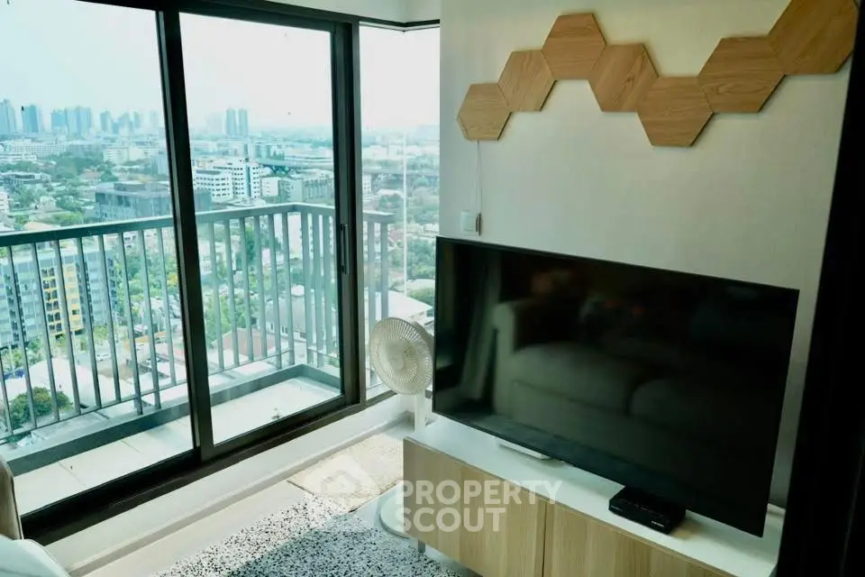 Modern living room with large window offering stunning city view and stylish decor.