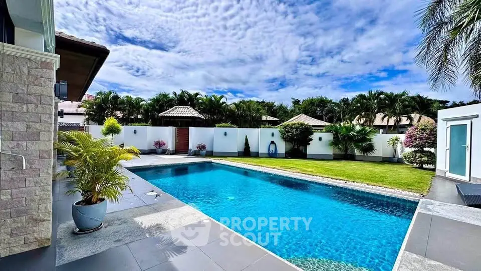 Luxurious private pool with lush garden and modern design in tropical setting.