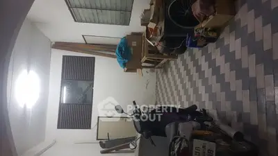 Spacious storage area with tiled flooring and ample space for vehicles and belongings.