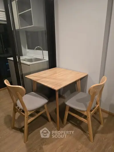 Cozy dining nook with wooden table and chairs near modern kitchen