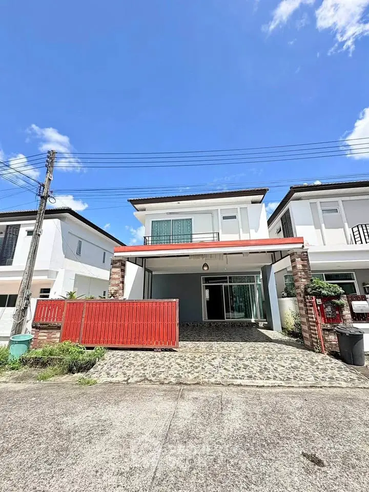 Modern two-story house with spacious driveway and red fence under clear blue sky.