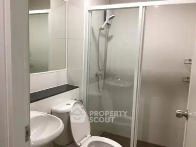 Modern bathroom with glass shower enclosure and sleek fixtures