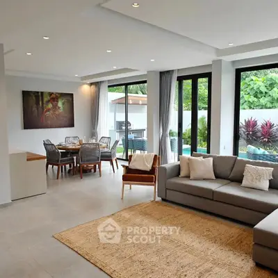Spacious modern living room with large windows and garden view, featuring elegant dining area and cozy seating.