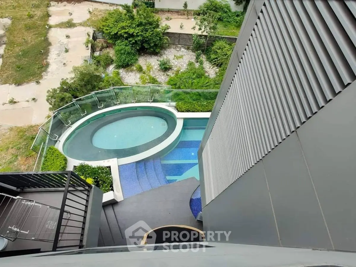 Stunning aerial view of modern residential pool with sleek design and lush greenery.