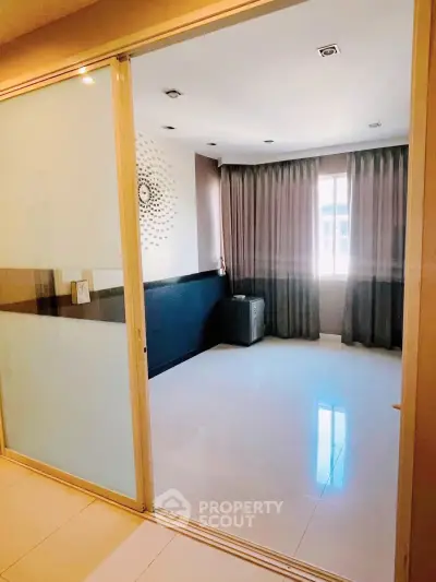 Spacious room with large window and modern decor in a stylish apartment.