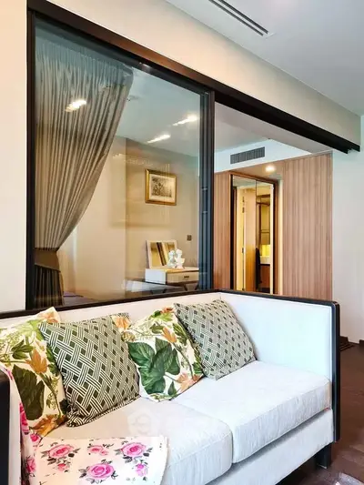 Modern living room with stylish sofa and glass partition in a contemporary apartment.