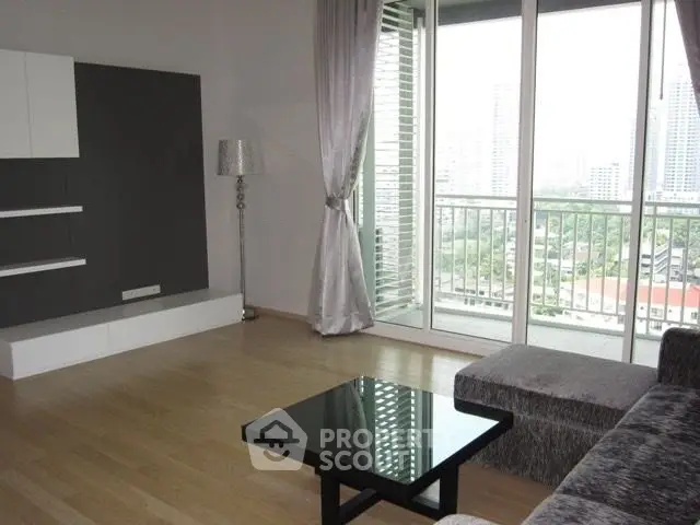Spacious living room with modern decor and city view balcony in high-rise apartment.