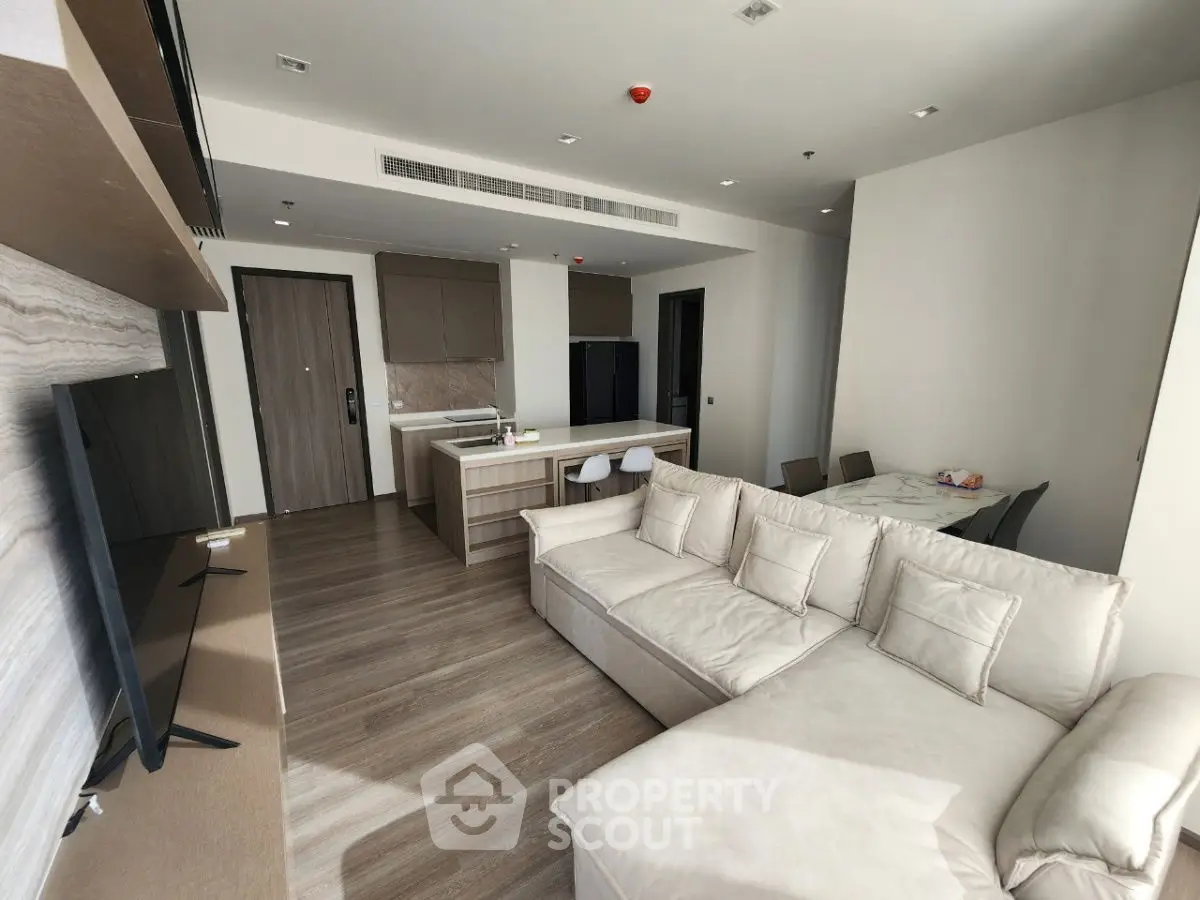 Modern living room with open kitchen layout and stylish furniture