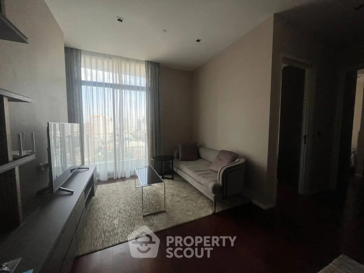 Cozy living room with modern decor and large window offering city views.