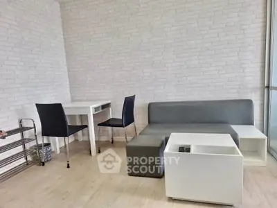 Modern minimalist living room with sleek furniture and white brick accent wall.