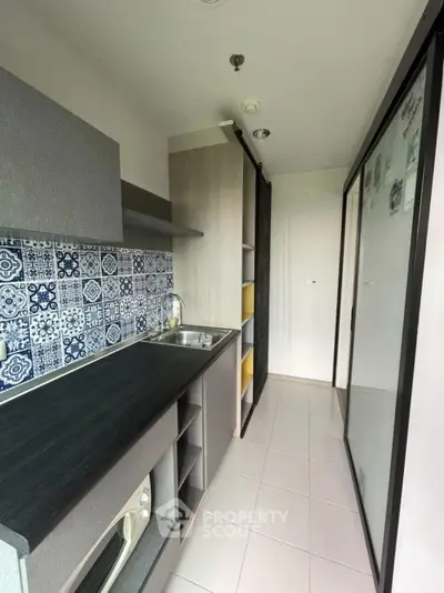 Modern kitchen with stylish backsplash and sleek cabinetry in compact layout