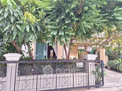 Charming residential property with lush greenery and secure gated entrance.