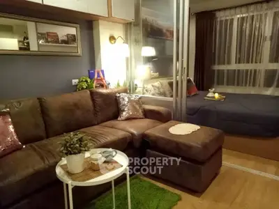 Cozy living room with brown leather sofa and adjacent bedroom in modern apartment