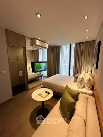 Modern bedroom with cozy seating area and stylish decor, featuring a large bed and ambient lighting.