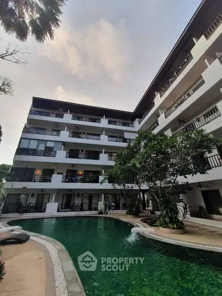 Stunning apartment building with lush poolside view and modern balconies.