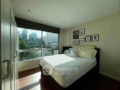 Spacious bedroom with city view and modern decor in urban apartment