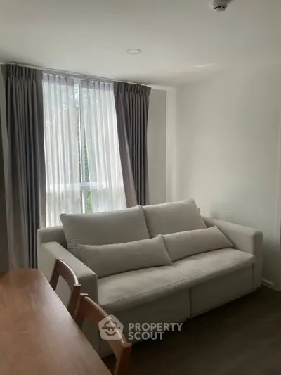 Cozy living room with natural light and modern furniture, perfect for relaxation.