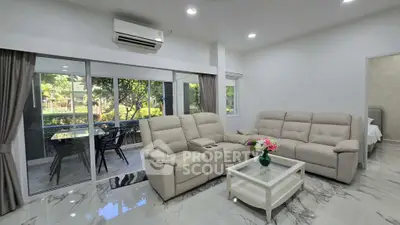 Spacious living room with modern furniture and garden view, perfect for relaxation and entertaining.